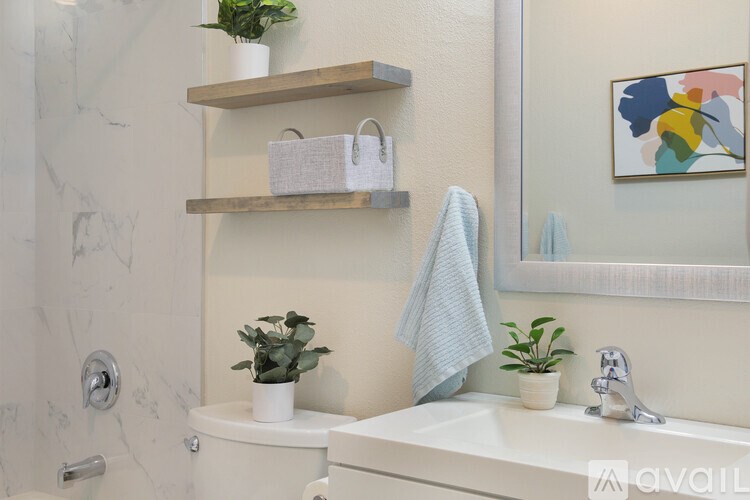 A bathroom with a white toilet, a white sink, and a mirror.