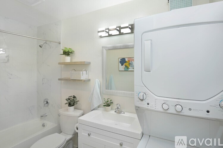 A bathroom with a white tub, toilet, and sink.