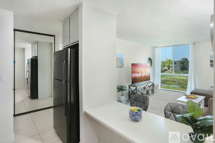 A modern kitchen with a black fridge and a white countertop.