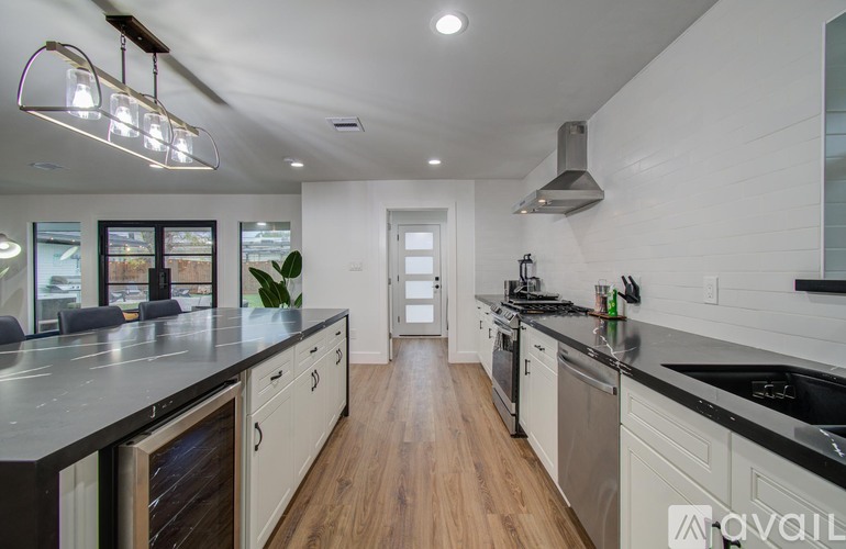 A modern kitchen with a long counter and a stainless steel dishwasher.