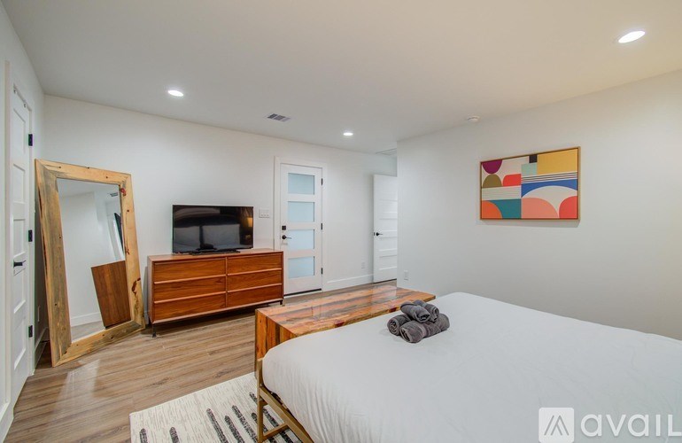 A bedroom with a bed, dresser, and mirror.