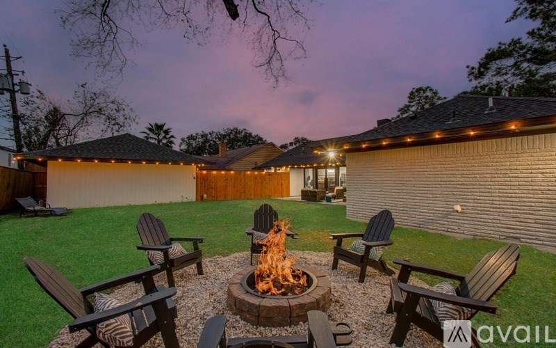 A backyard with a fire pit and chairs.