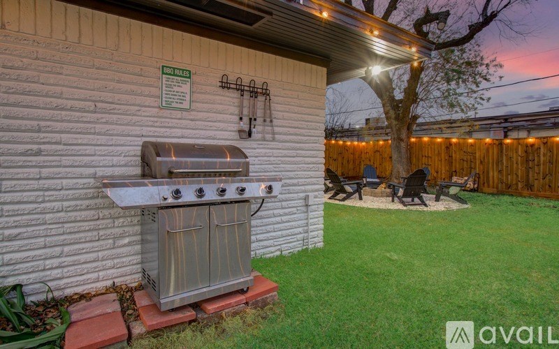 A backyard with a grill and a picnic table.