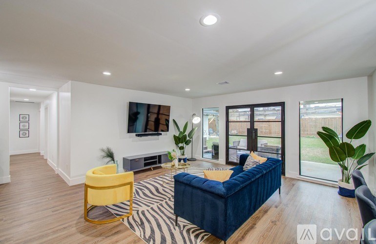A living room with a blue sofa, yellow chair, and a zebra rug.