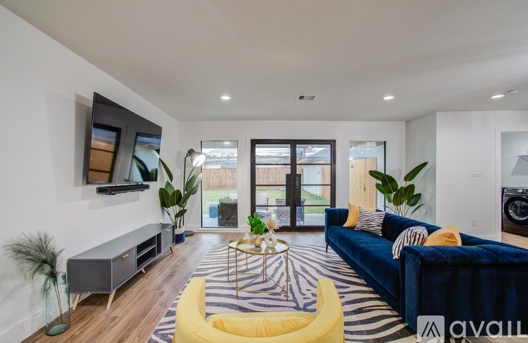 A living room with a blue couch and a yellow chair.