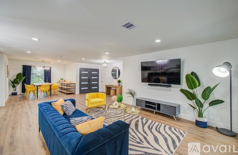 A living room with a blue couch and yellow chairs.