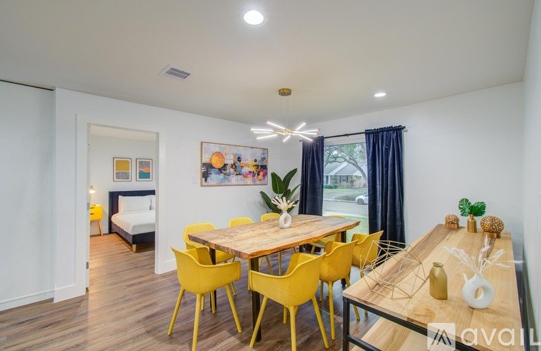 A dining room with a wooden table and yellow chairs.