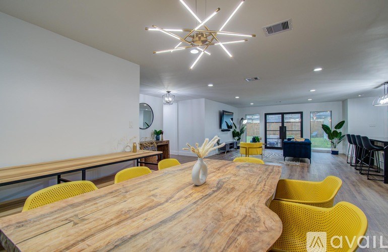 A wooden table surrounded by yellow chairs in a well-lit room.