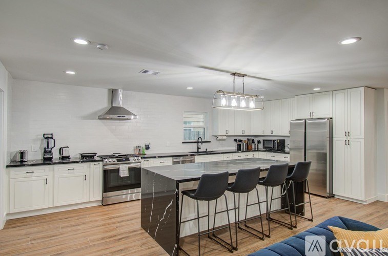A kitchen with a marble island and modern appliances.