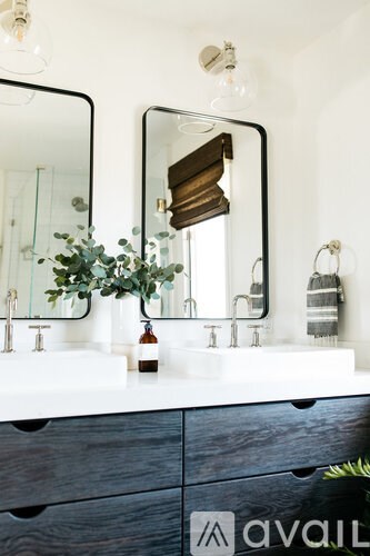 A bathroom with a white countertop and a mirror above it.