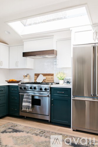 A modern kitchen with a stainless steel refrigerator and oven.