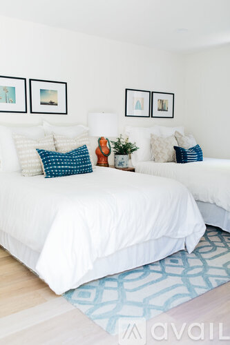 A bedroom with two beds and a rug.