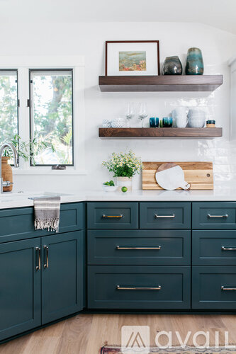 A kitchen with dark green cabinets and a white countertop.