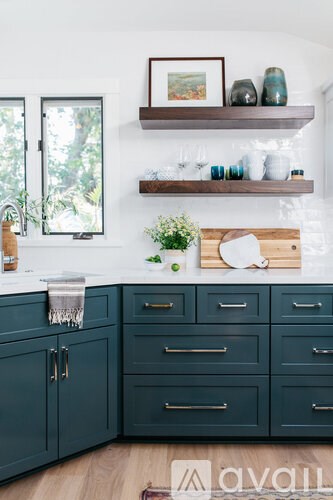 A kitchen with dark green cabinets and a white countertop.