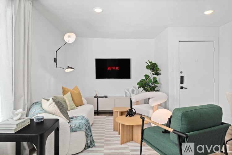 A living room with a green armchair and a white sofa.