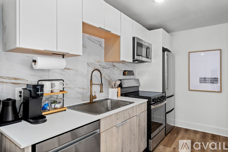 A kitchen with white cabinets and a marble backsplash.