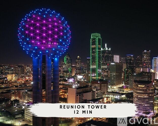 A cityscape at night with a Reunion Tower and a tall green building.