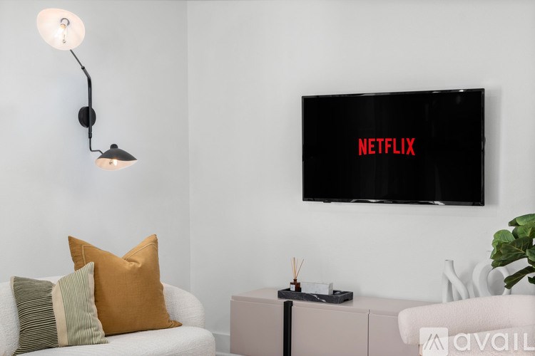 A living room with a Netflix branded television mounted on the wall.