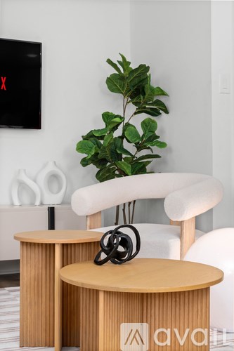 A white chair with a wooden table and a potted plant in a room.