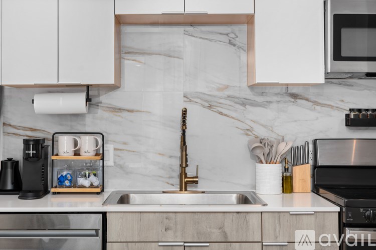 A kitchen with a marble backsplash and stainless steel appliances.