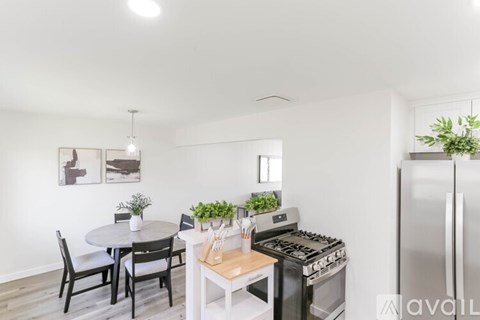 A modern kitchen with a dining table and chairs.