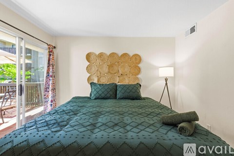 A bedroom with a large bed and a decorative wall piece.