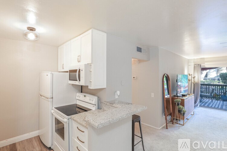 A kitchen with white appliances and cabinets.