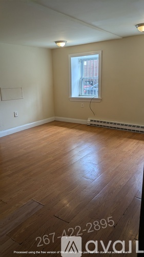 A room with wooden floors and a glass door leading to another room.