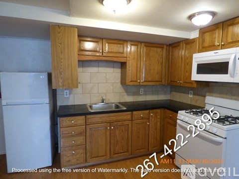 A kitchen with wooden cabinets and a white refrigerator.