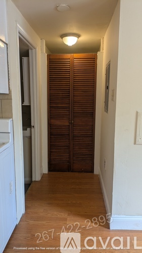 A white toilet is in a small bathroom with a walk-in shower.