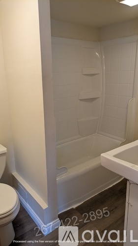 A white bathroom with a toilet, tub, and sink.