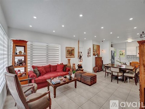 A living room with a red couch and wooden furniture.