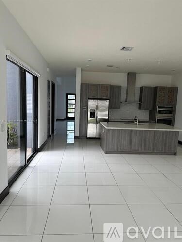 A spacious kitchen with a refrigerator, oven, and cabinets.