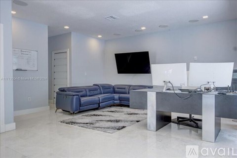 A modern living room with a blue sofa and a television mounted on the wall.