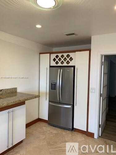 A kitchen with a refrigerator and cabinets.