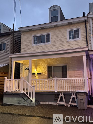 A house with a porch and a sign that says "avail".