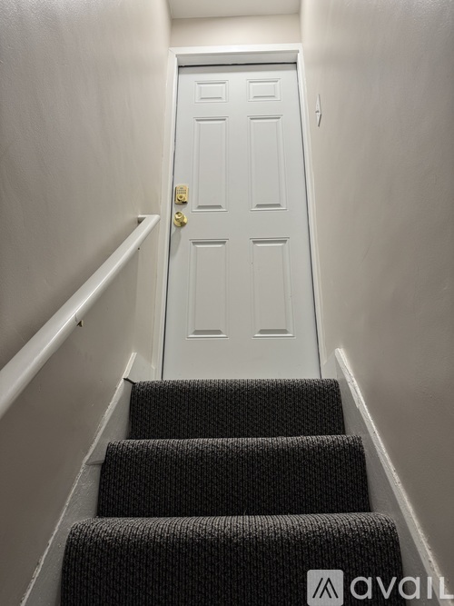 A white door is at the end of a staircase.