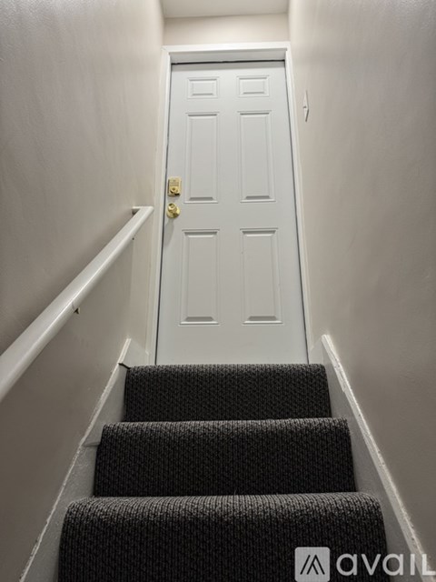 A white door is at the end of a staircase.
