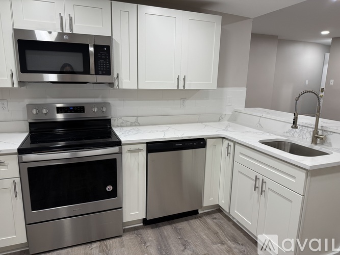 A kitchen with white cabinets and a stainless steel oven.