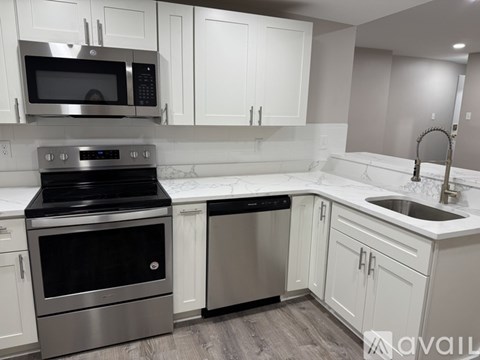 A kitchen with white cabinets and a stainless steel oven.