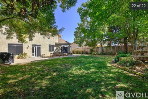 A house with a yard and trees in front of it.