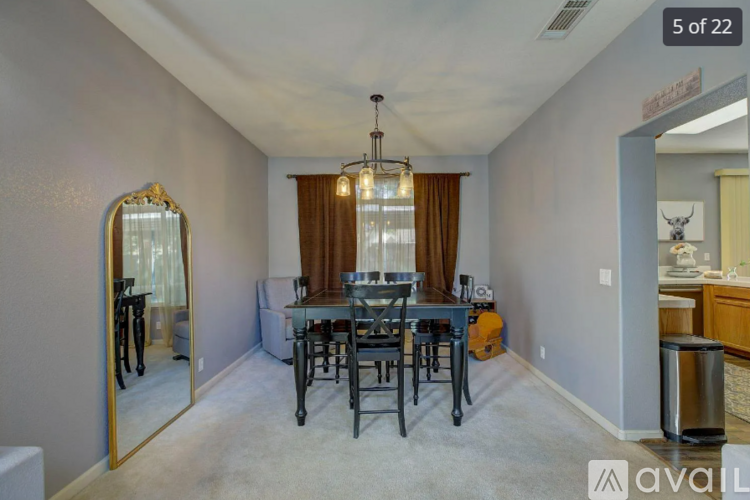 A dining room with a table set for six and a mirror on the wall.