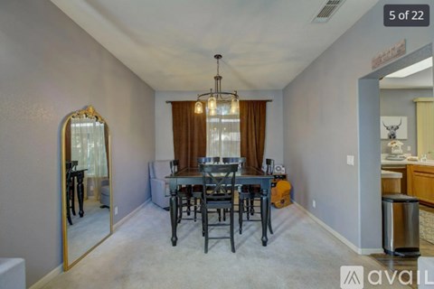 A dining room with a table set for six and a mirror on the wall.