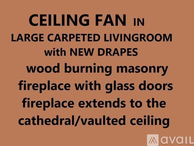 Ceiling fan in a large carpeted living room with new drapes and a wood burning masonry fireplace with glass doors.