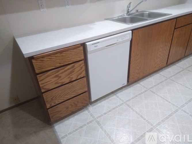 A kitchen with a white countertop and a white dishwasher.