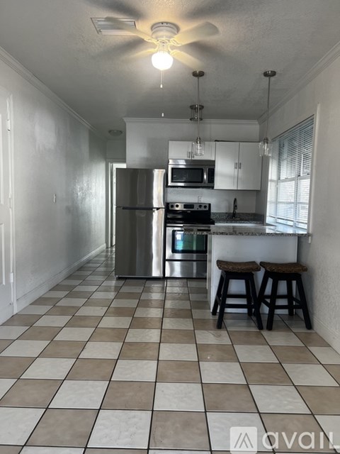 A kitchen with a checkered floor and a refrigerator.
