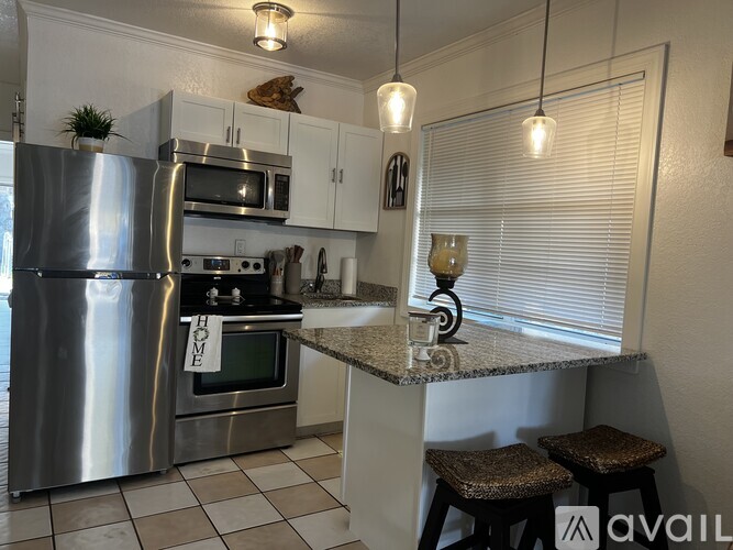 A kitchen with a stainless steel refrigerator, microwave, and oven.