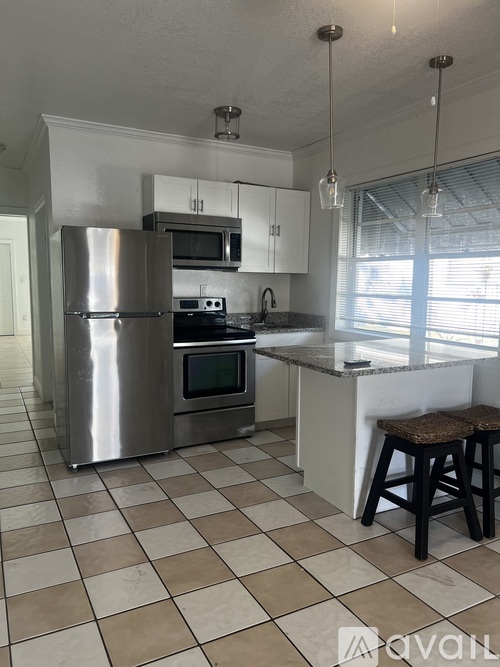 A kitchen with a checkered floor and a stainless steel refrigerator.