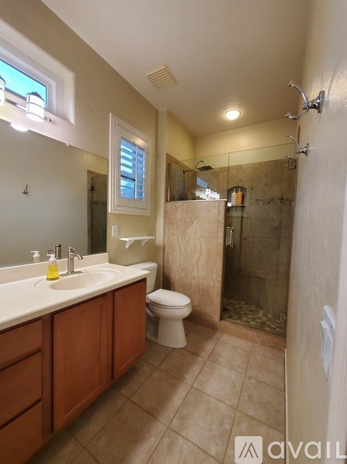 A bathroom with a toilet, sink, and shower.
