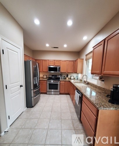 A kitchen with wooden cabinets and a refrigerator.